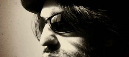 Closely cropped Black and white photo of Berdandy in a hat and sport sunglasses